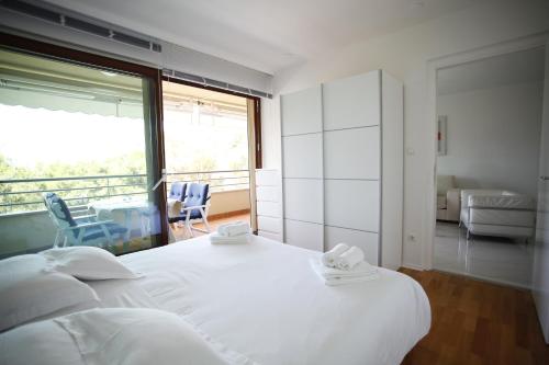 a bedroom with a large white bed and a balcony at Residence Art Split in Podstrana