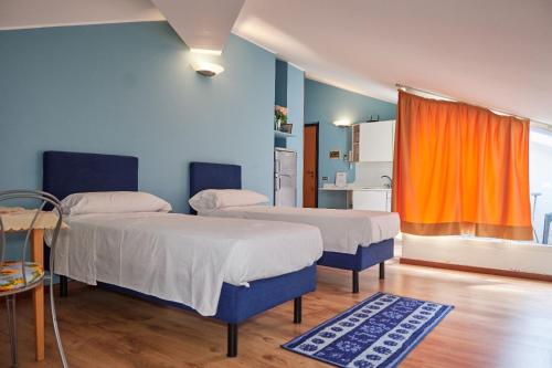 um quarto com duas camas e uma cortina laranja em Alloggio centro Monza em Monza
