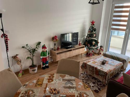 een woonkamer met een kerstboom en een televisie bij Golden Apartments Skopje in Skopje