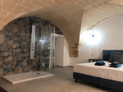 a bedroom with a shower in a stone wall at I Venti in Taranto