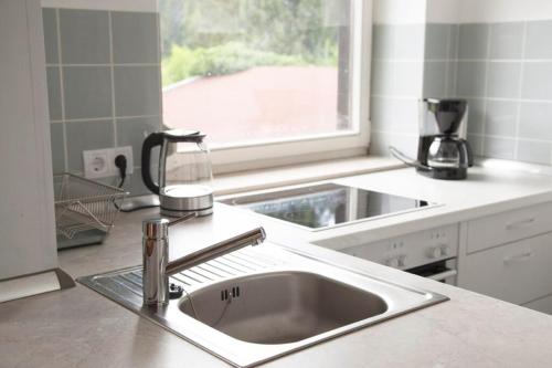 a kitchen counter with a sink and a window at Haus Oberwössen in Unterwössen