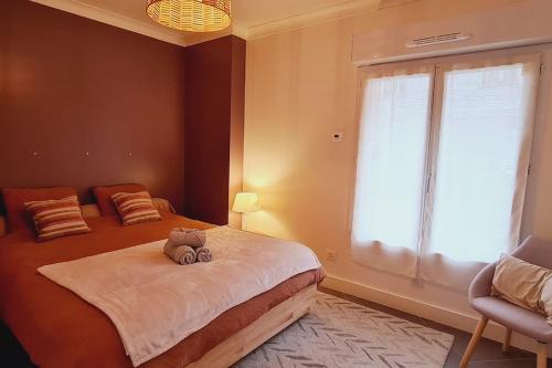 um quarto com uma cama com um bicho de peluche em Appartement 2 pièces centre ville avec parking em Neauphle-le-Château