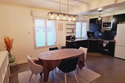 uma cozinha com mesa e cadeiras num quarto em Appartement 2 pièces centre ville avec parking em Neauphle-le-Château