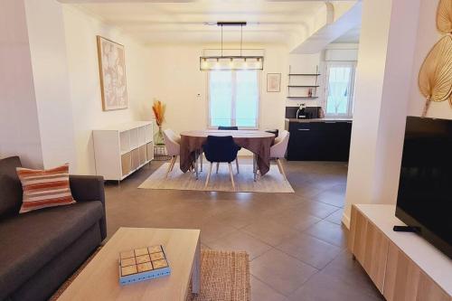 uma sala de estar com um sofá e uma mesa em Appartement 2 pièces centre ville avec parking em Neauphle-le-Château