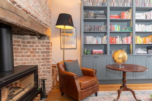 a living room with a chair and a book shelf at Elegant & Modern 5BD Home w Garden - Greenwich! in London