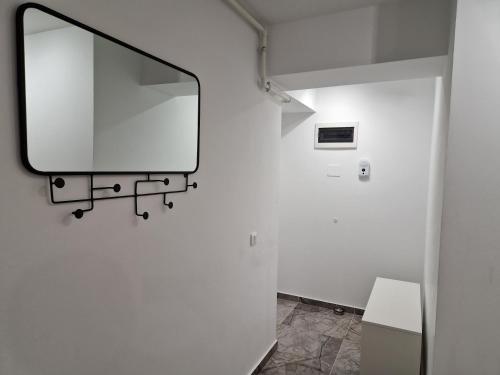 einen Spiegel an der Wand eines Badezimmers in der Unterkunft Golden Airport Residence in Otopeni