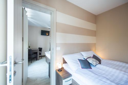 a bedroom with a bed with a striped wall at Hotel Pri mostu in Dolenjske Toplice