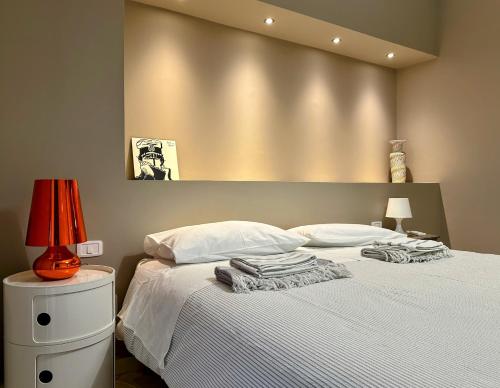 sypialnia z łóżkiem z białą pościelą i lampką w obiekcie Casa Cavour w mieście Misterbianco