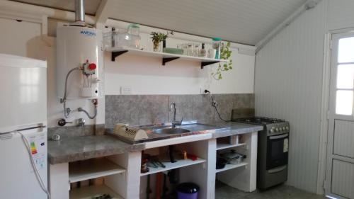 a small kitchen with a sink and a stove at Refugio Amaicha in Embalse