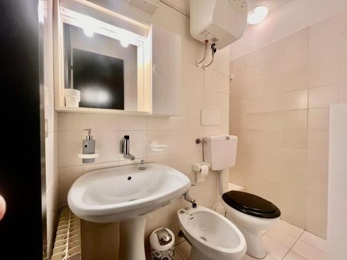 a white bathroom with a sink and a toilet at Piancavallo Panoramica in Piancavallo