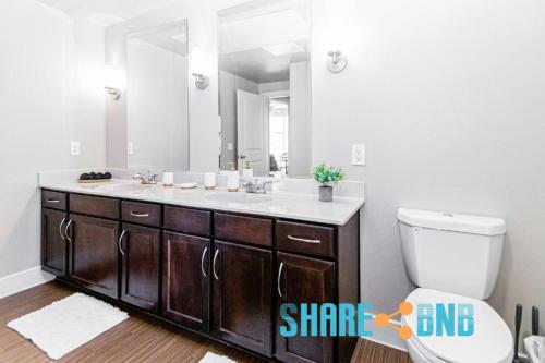 a bathroom with a sink and a toilet and a mirror at Twin Apartments-great For Groups in Dallas