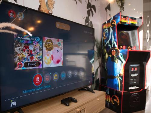 einen Flachbild-TV auf einem Holztisch in der Unterkunft Gloucester getaway with gaming room, desk & parking in Gloucester