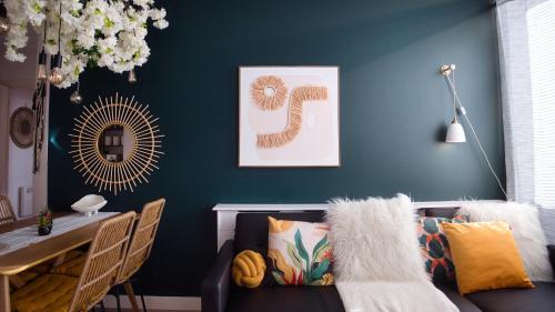 a living room with a blue wall with a couch at 2-bed near Gloucester & Cotswolds - 2x parking, desk, fibre, arcade in Gloucester