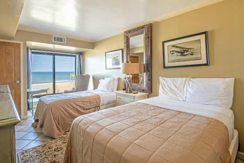 two beds in a hotel room with a view of the ocean at The Colony at Virginia Beach by TripForth in Virginia Beach