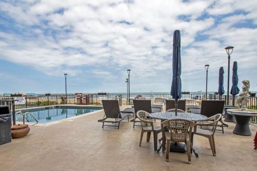 a patio with a table and chairs and a pool at The Colony at Virginia Beach by TripForth in Virginia Beach
