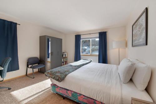 a bedroom with a bed and a chair and a window at Fawn Court - Wildernest in Silverthorne