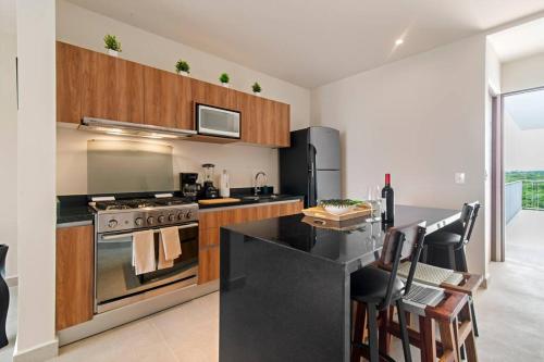 a kitchen with a stove and a counter top at Seahorse Private Rooftop Hot tub Ocean View Beach Access 11 Pools in Akumal