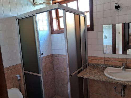 uma casa de banho com um chuveiro e um lavatório. em Pousada Sol da Lagoinha em Ubatuba
