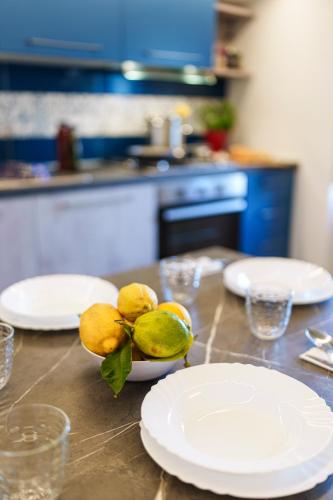 a table with white plates on top of a kitchen at Holidays Homes The dream in Sant'Agnello