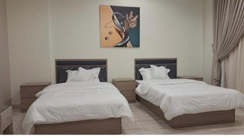 النظافه والجوده في الرياض: غرفة نوم بها سريرين ولوحة على الحائط