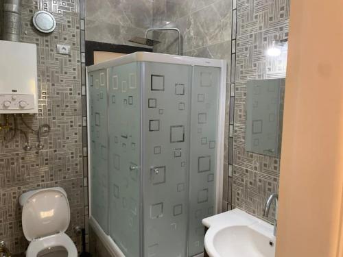 a bathroom with a white toilet and a sink at Easttown Central Park apartment in Cairo