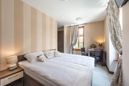 una camera con un grande letto e una scrivania di Hotel Pri mostu a Dolenjske Toplice