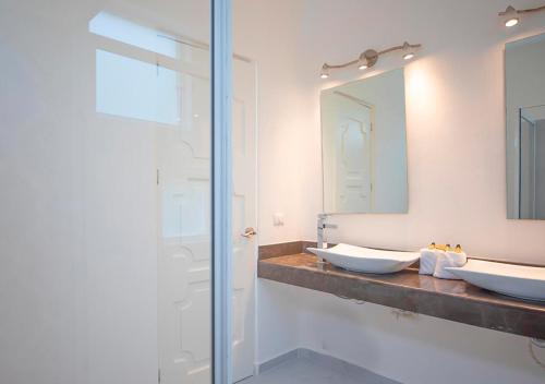 a bathroom with two sinks and a mirror at La Bella Vita Tulum in Tulum