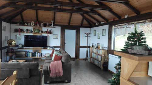 a living room with two couches and a christmas tree at Trout Cottage in Bran