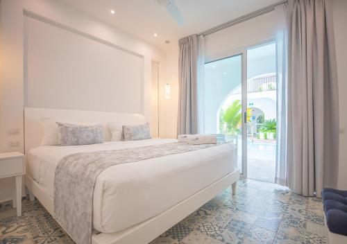 a bedroom with a large bed and a large window at La Bella Vita Tulum in Tulum