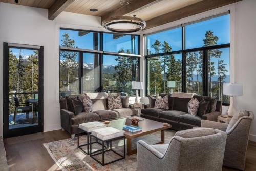 a living room filled with furniture and large windows at 9 Deep Forest Drive by Moonlight Basin Lodging in Big Sky