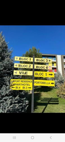 a yellow directional sign in front of a building at Golden Airport Residence in Otopeni