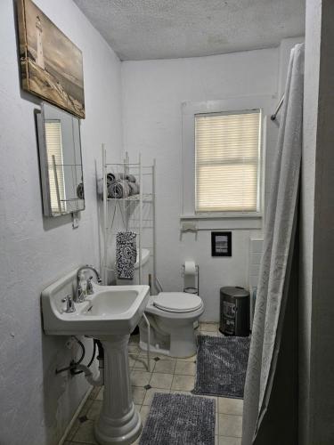 La salle de bains blanche est pourvue d'un lavabo et de toilettes. dans l'établissement The Bungalow, à Seymour