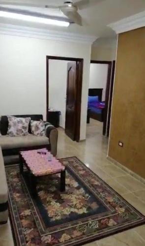 sala de estar con sofá y mesa en شقة عيسى en Dumyāţ al Jadīdah