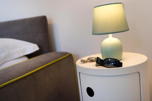 a lamp on a night stand next to a bed at Holidays Homes The dream in Sant'Agnello