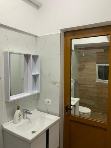 y baño con lavabo, aseo y espejo. en Villa Ermali, en Ksamil