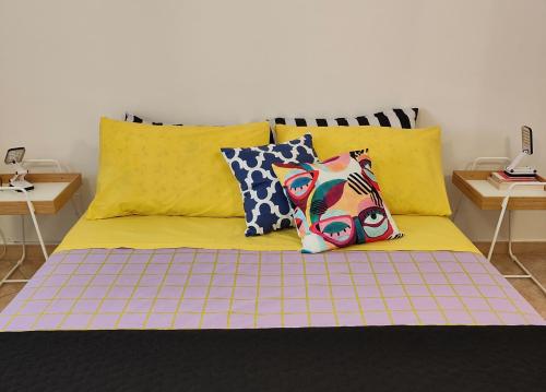 una cama con almohadas coloridas en una habitación en Casa Liza en Anguillara Sabazia