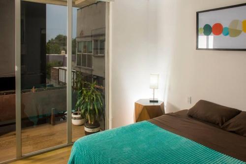 a bedroom with a bed and a large window at Spacious, Modern Luxury in Roma Norte in Mexico City