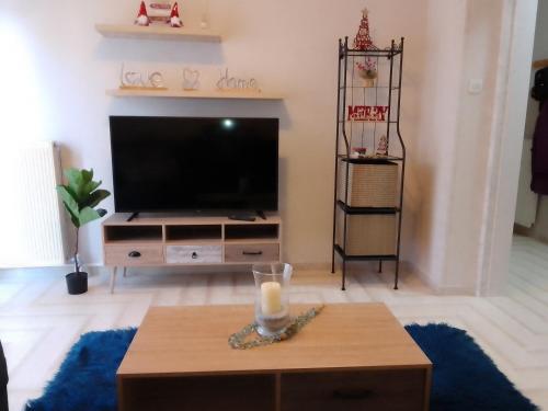 a living room with a tv and a table with a candle at Volos Hospitality, Central Apartment in Volos