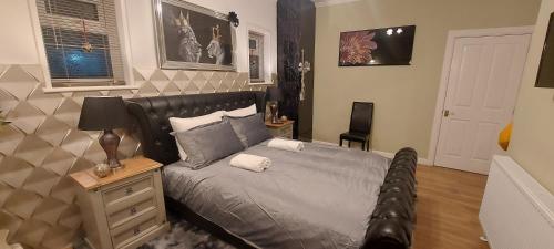 a bedroom with a bed with a black leather headboard at OLIVE TREE - 2 Master bedroom (sleeps 6) in Blackpool