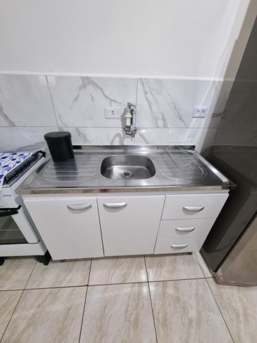 a small kitchen with a sink and a stove at Studio Ideal in São Paulo