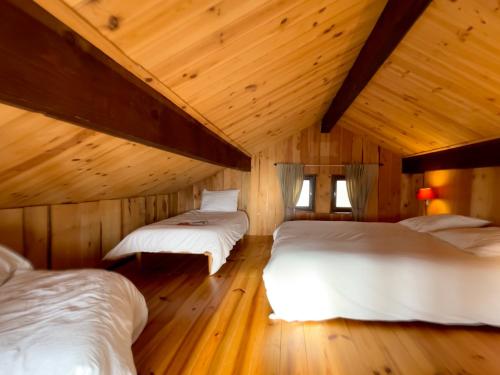 deux lits dans une chambre avec plafonds en bois dans l'établissement Chalet en cascade Les Angles vue Panoramique, aux Angles