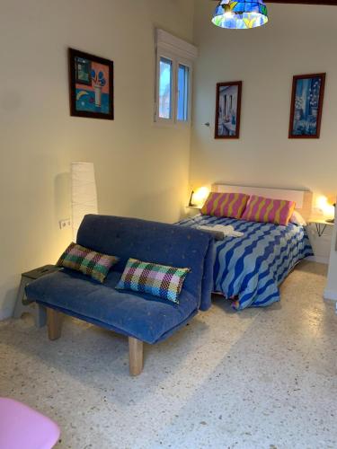 a living room with a blue couch and a bed at Centauro in Albir
