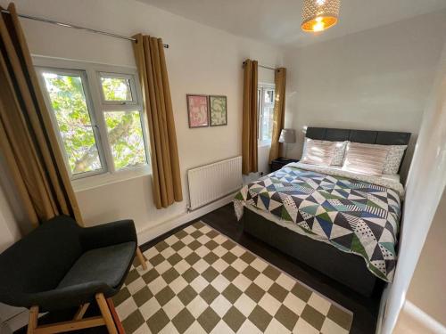 um quarto com uma cama, uma cadeira e uma janela em Cozy 2 bedroom flat Tower Bridge / Bermondsey em Londres