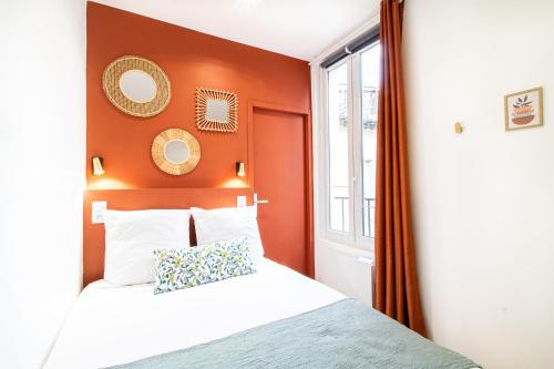 - une chambre avec un lit aux murs orange et une fenêtre dans l'établissement Appartement Cosy Nîmes-Centre 2, à Nîmes