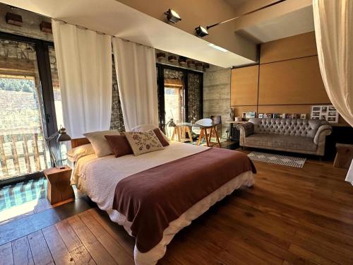 1 dormitorio con 1 cama grande y sala de estar en Loft Rural LaCalata, en Calatañazor