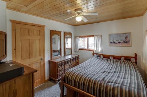- une chambre avec un lit, une commode et un miroir dans l'établissement Two Lakefront Whitefish Chain Cabins for price of one, à Cross Lake