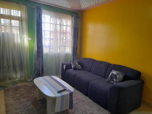 - un salon avec un canapé et une table basse dans l'établissement Pk cosy apartment, à Nairobi