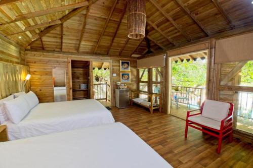 a bedroom with two beds and a chair in a room at Hotel Isla del Encanto in Baru