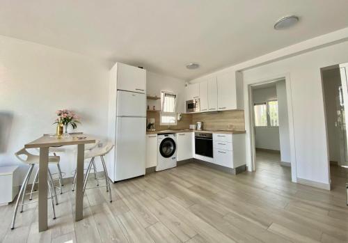 a kitchen with a table and a white refrigerator at Sofia23 in Costa Calma