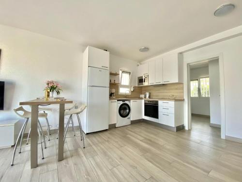 a kitchen with white appliances and a table with chairs at Sofia23 in Costa Calma